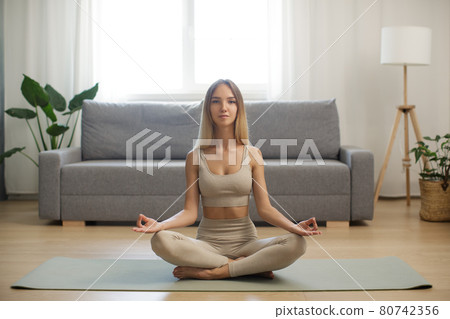 Woman in Meditation on Yoga Mat at Home 80742356