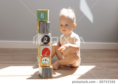 Cute little boy child playing at home with colorful cubes 80743588