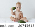 little boy holds avocado in his hands and smiles. 80743618