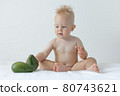 little boy holds avocado in his hands and smiles. 80743621
