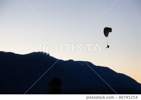 Adventurous Woman Flying a paraglider and coming in for landing. 80745254