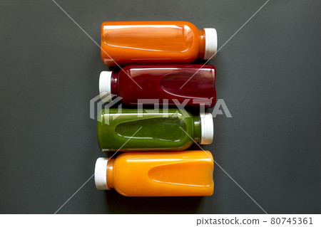 Fresh juices or smoothies of fruits and vegetables in bottles on a gray background. Flat Ley, top view. Fresh juices or smoothies of fruits and vegetables in bottles on a gray background. Flat Ley, top view. 80745361
