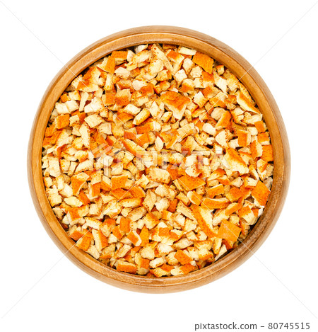 Dried organic orange peel, cut into coarse pieces, in a wooden bowl. Cut skin of organic oranges, used for baking, or for teas. Close-up, from above, isolated on white background, macro food photo. 80745515