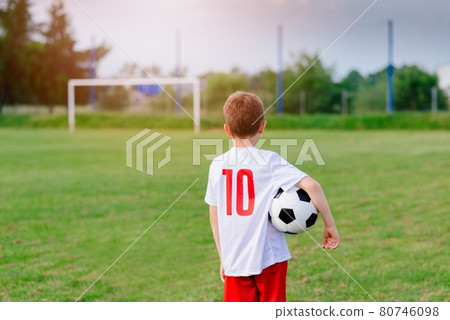 8 years old boy child holding football ball on playing field. 8 years old boy child holding football ball on playing field. 80746098