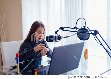 Blogger girl recording video broadcast with microphone about new cosmetic products. Blogger girl recording video broadcast with microphone about new cosmetic products. 80746122