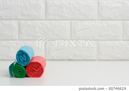 stack of disposable plastic trash can bags on white table, white brick wall background stack of disposable plastic trash can bags on white table, white brick wall background 80746629