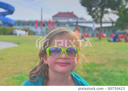 Happy kid at aqua. Little girl in sunglasses on a summer sunny day. Summer holiday concept Happy kid at aqua. Little girl in sunglasses on a summer sunny day. Summer holiday concept 80750423