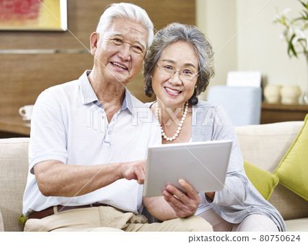 happy asian senior couple with tablet computer looking at camera smiling 80750624