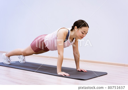 happy woman doing sports at home against wall background happy woman doing sports at home against wall background 80751637