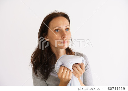 Woman holding clean white scented shirt Woman holding clean white scented shirt 80751639