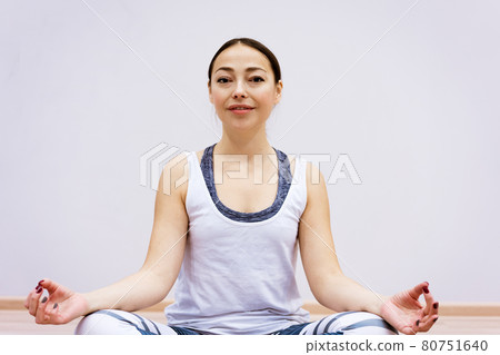 Happy woman doing yoga at home against wall background Happy woman doing yoga at home against wall background 80751640