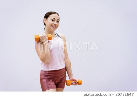 Happy woman doing fitness with dumbbells Happy woman doing fitness with dumbbells 80751647