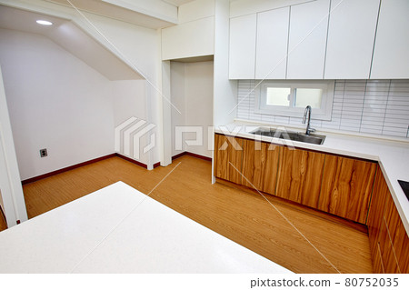 Table and dining table in a clean and simple modern open kitchen Table and dining table in a clean and simple modern open kitchen 80752035