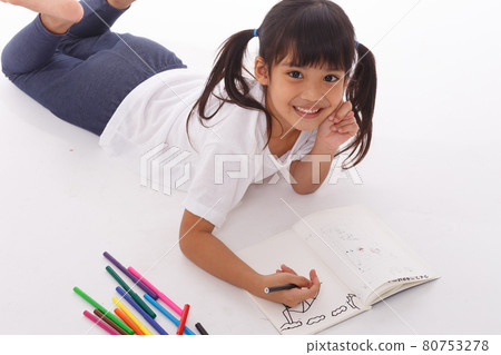 Cute little girl doing homework, reading a book, coloring pages, writing and painting. Children paint. Kids draw. Preschooler with books at home. Cute little girl doing homework, reading a book, coloring pages, writing and painting. Children paint. Kids draw. Preschooler with books at home. 80753278