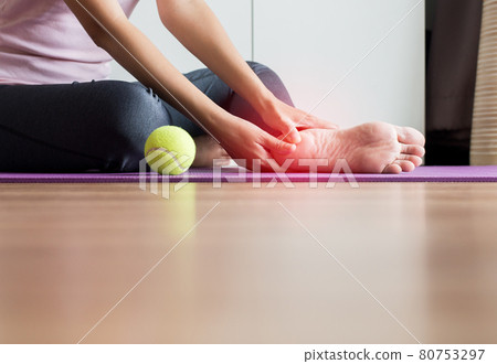 Woman hands massage to her foot on yoga mat at home,Feet soles massage for plantar fasciitis,Close up 80753297