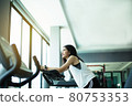 Fit young girl using exercise bike at the gym. Fitness female using air bike at gym. 80753353