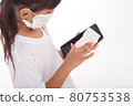 Asian girl wear mask cleaning smartphone screen with alcohol.on white background. Concept of Cleaning dirty screen phone for disease prevention from bacteria. 80753538