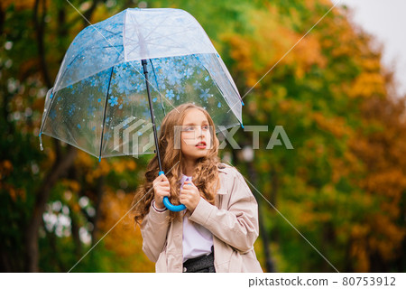 Young attractive smiling girl under umbrella in autumn forest Young attractive smiling girl under umbrella in autumn forest 80753912