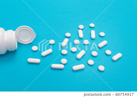 Pharmaceutical Industry and Medicinal Products - White Pills on Blue Table Pharmaceutical Industry and Medicinal Products - White Pills on Blue Table 80754917