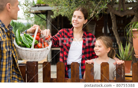 Family talking about rich harvest at backyard 80755388