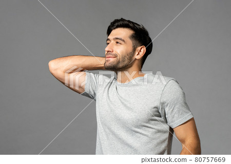 Young man smiling with hand behind neck, looking away and thinking after wake up Young man smiling with hand behind neck, looking away and thinking after wake up 80757669