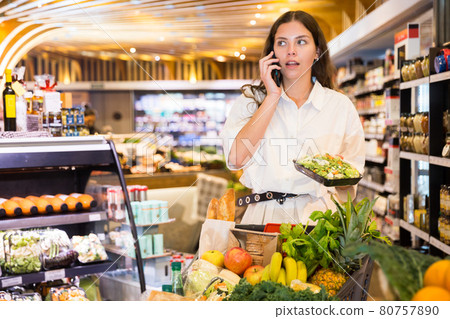 Young woman talking by phone during shopping Young woman talking by phone during shopping 80757890
