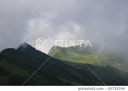 Chalet Vieux and green mountain meadows on a rainy summer day. Chalet Vieux and green mountain meadows on a rainy summer day. 80758394