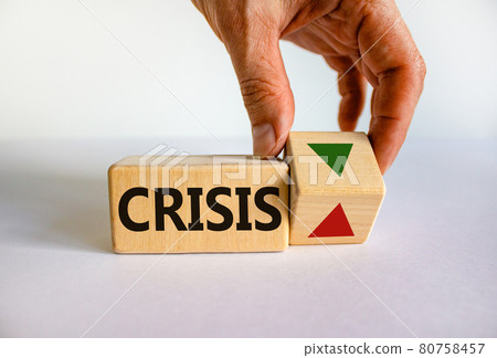 Crisis symbol. Wooden cube with word 'crisis'. Businessman turns the wooden cube, changes the direction of an arrow down or up. Beautiful white background. Copy space. Business and crisis concept. 80758457