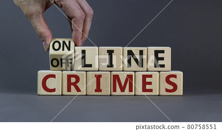 From offline to online crimes. Male hand flips a cube and changes the words 'offline crimes' to 'online crimes'. Beautiful grey background. Copy space. Business and online crimes concept. 80758551