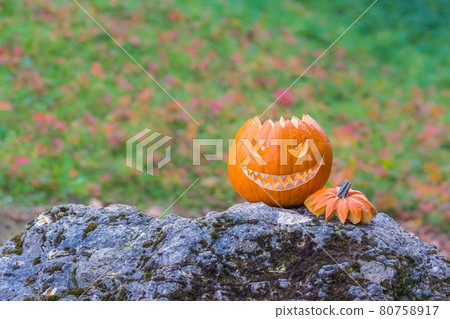 Scary smiling face halloween pumpkin on a stone 80758917