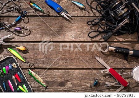 Fishing tackle - fishing spinning, fishing line, hooks and lures on wooden background. 80758933