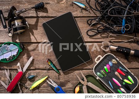 Fishing tackle - fishing spinning, fishing line, hooks and lures on wooden background. 80758936