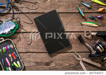 Fishing tackle - fishing spinning, fishing line, hooks and lures on wooden background. 80758937