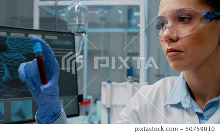 Close up of scientist analyzing lab vacutainer with fluid Close up of scientist analyzing lab vacutainer with fluid 80759010