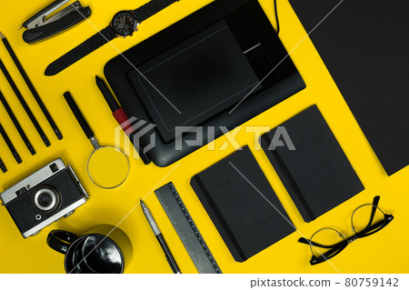 Black objects from the office on a yellow background. Work and creativity. Top view. 80759142