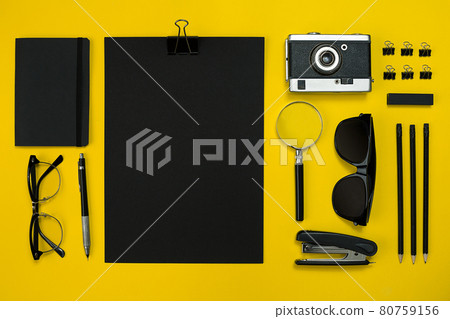 Flat lay display of business office gadgets with notepad, vintage camera, pen, develop, glasses and etc. Top view. Black office objects on a yellow background 80759156