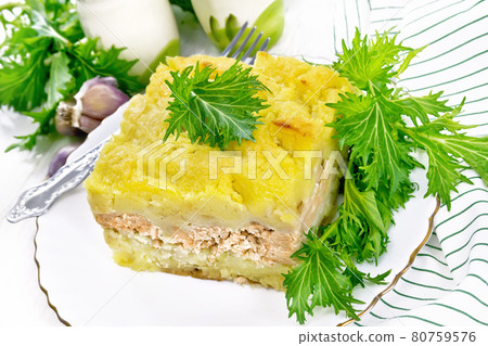 Casserole with potatoes and fish in plate on white wooden board Casserole with potatoes and fish in plate on white wooden board 80759576