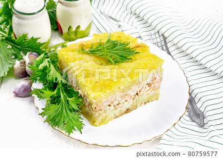 Casserole with potatoes and fish in plate on white board Casserole with potatoes and fish in plate on white board 80759577