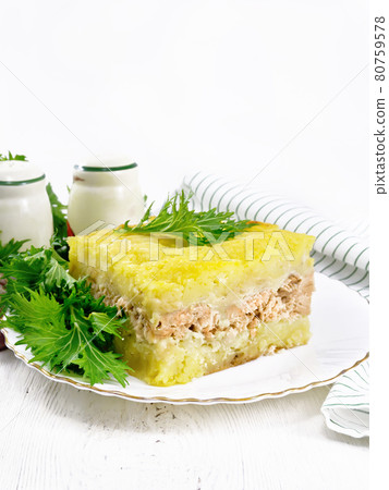 Casserole with potatoes and fish in plate on light table Casserole with potatoes and fish in plate on light table 80759578