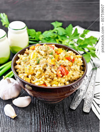 Barley porridge with minced meat in bowl on dark wooden board Barley porridge with minced meat in bowl on dark wooden board 80759607