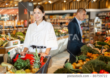 Portrait of a happy girl with a grocery cart in the supermarket 80759722