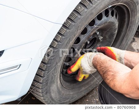 technician attaches a winter car wheel outdoors technician attaches a winter car wheel outdoors 80760908
