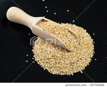 scoop on unhulled foxtail millet seeds on black 80760966