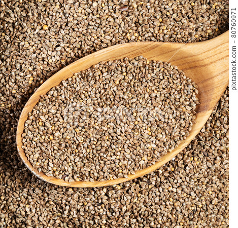 unhulled barnyard millet seeds in wood spoon 80760971