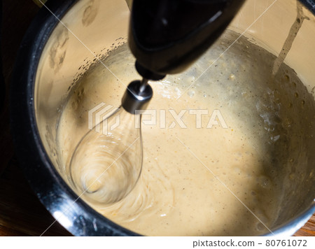 stirring of liquid dough in steel bowl by blender 80761072