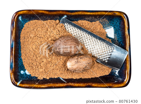 nutmeg seeds, powder and grater in bowl cutout 80761430