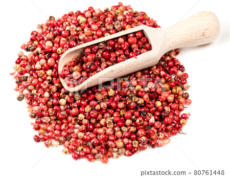 scoop on pile of pink peppercorns on white 80761448