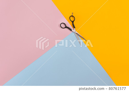 Scissors on the color pink, yellow, blue paper background. Top view. 80761577