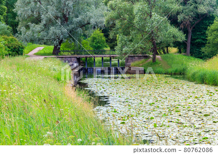 Black bridge-dam over the Slavyanka river in Pavlovsk park, Russia 80762086