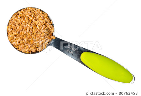 golden flax seeds in steel measuring spoon cutout 80762458